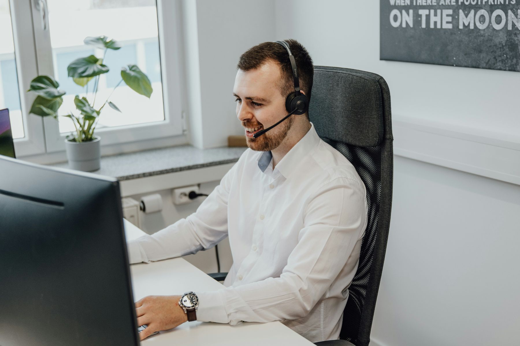 man met headset aan computer